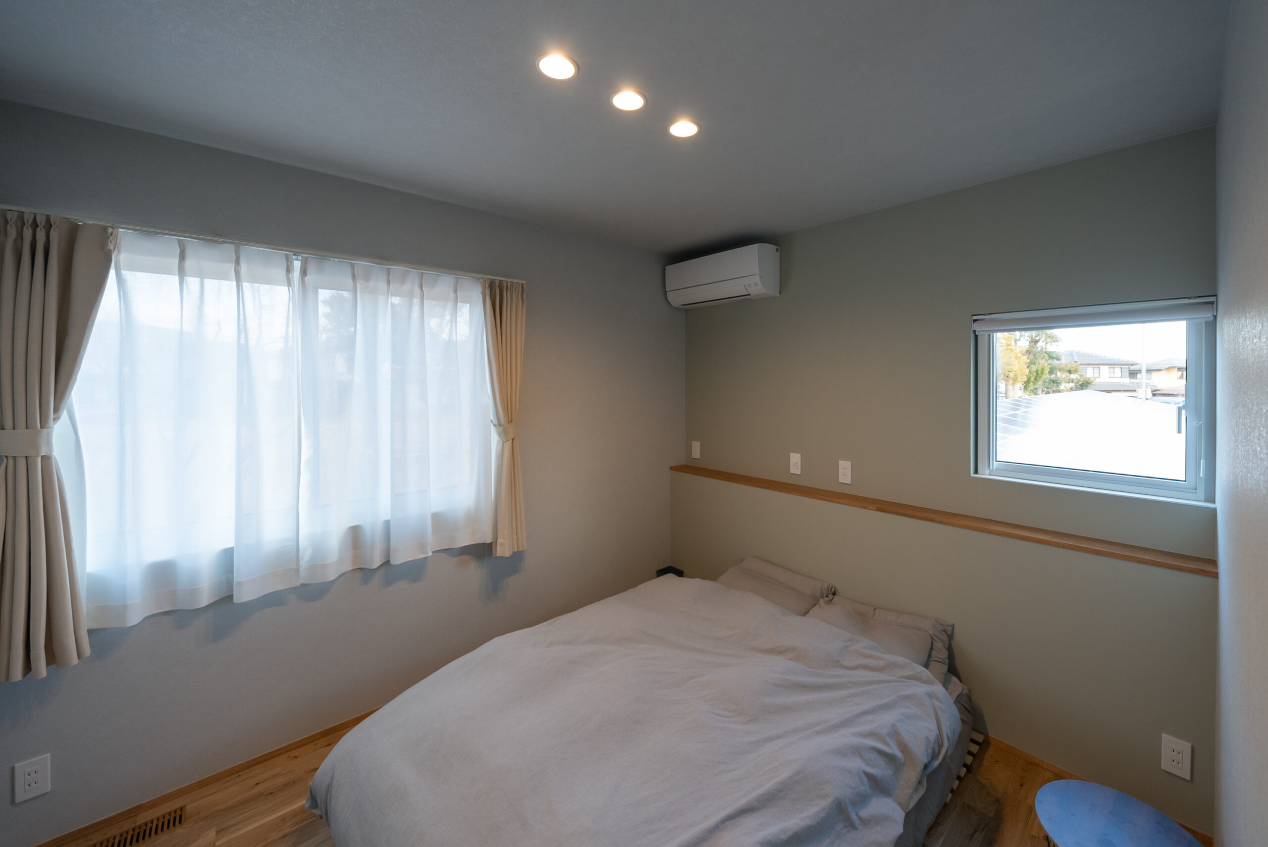 ベッド背面のカウンターにスマホなどを置ける工夫された寝室